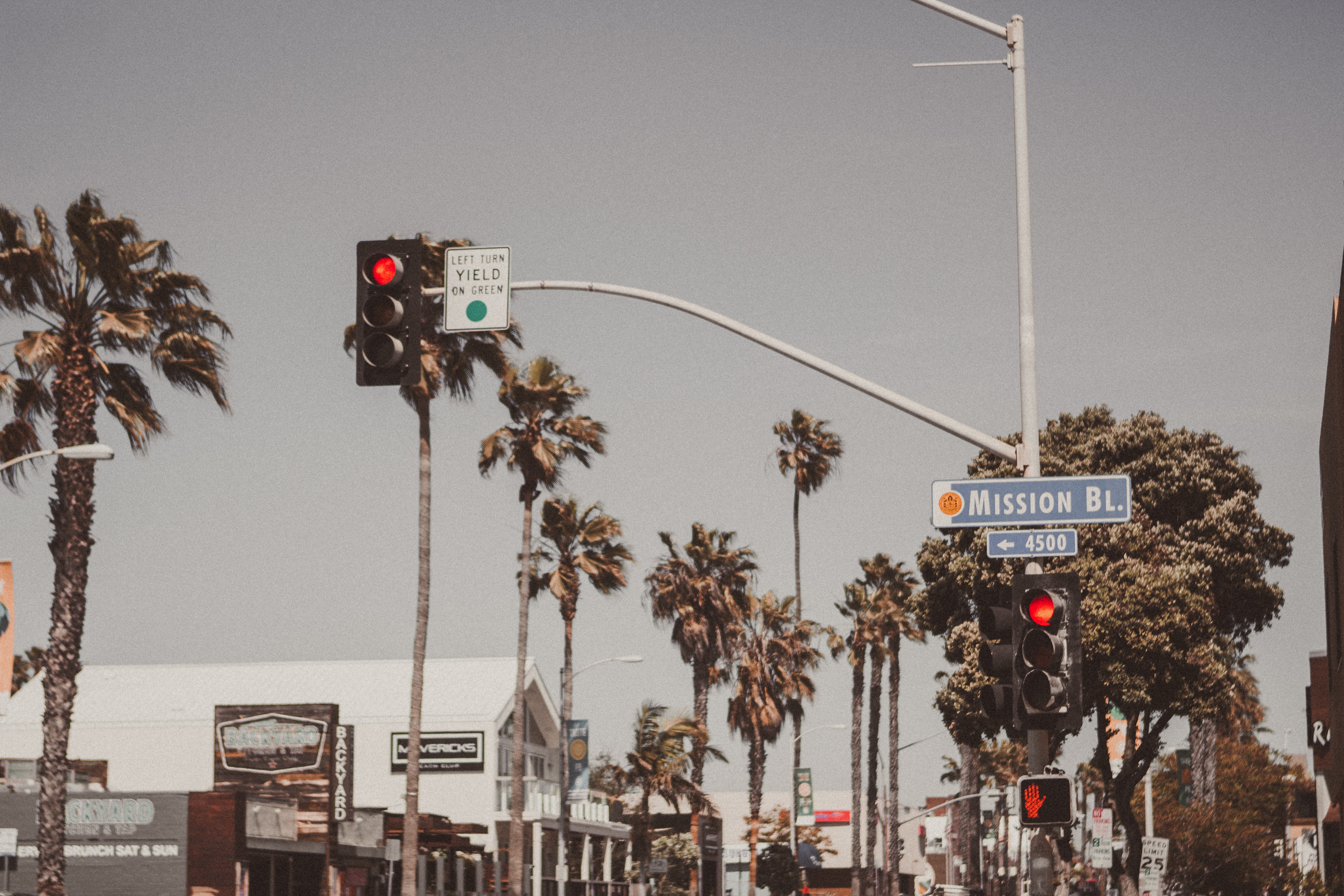 Palm trees, a traffic signal and a street light near Mission Boulevard in San Diego